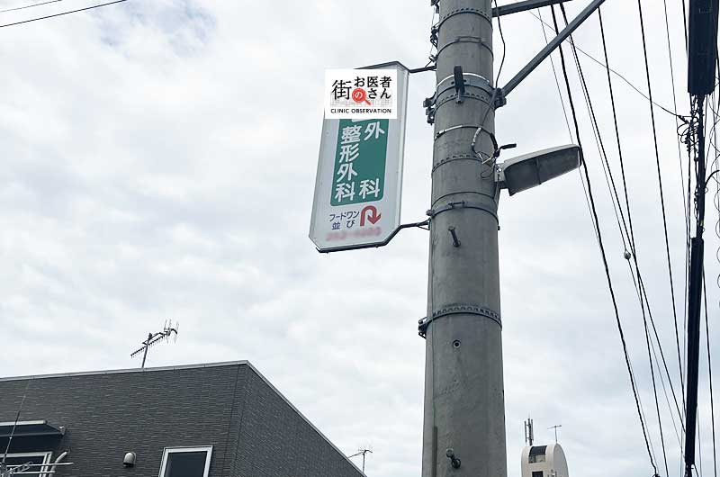 電柱広告の後ろ側にはさっきと同じ整形外科の看板のイメージ